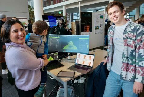 Lachende Studierende vor einem Computerbildschirm