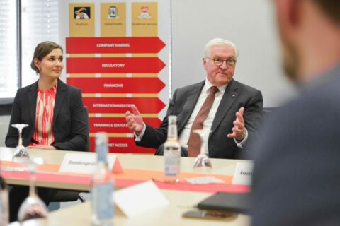 Anna Goldsworthy sitzt neben Bundespräsident Steinmeier. Im Hintergrund sind Schilder mit der Aufschrift "Company Making", "Regulatory", "Financing" und "Internationalization" zu sehen.
